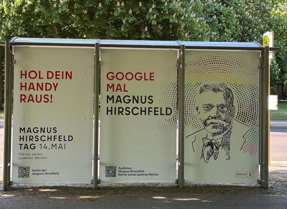 Die Rückseite der Gedenkhaltestelle "Magnus Hirschfeld" mit dem Logo/Portrait von ihm und dem Text: "Hol dein Handy raus! Google mal Magnus Hirschfeld
Magnus Hirschfeld Tag 14. Mai"