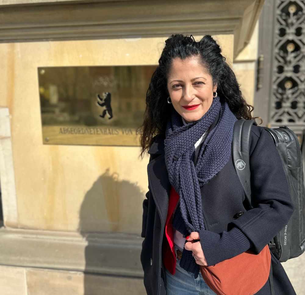 Senatorin für Arbeit, Soziales, Gleichstellung, Integration, Vielfalt und Antidiskriminierung Cansel Kiziltepe steht vor dem Eingang ins Berliner Parlament. Im Hintergrund ist ein goldfarbenes Schild mit der Aufschrift "Abgeordnetenhaus von Berlin" und dem Berliner Wappen zu sehen.