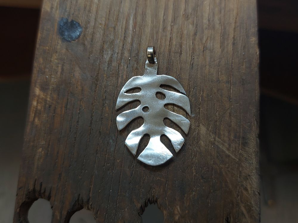monstera leaf pendant made from the eating end of a spoon