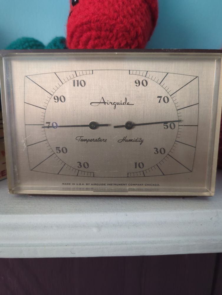 An old Airguide indoor thermometer hygrometer showing 68 °F and 52% humidity.