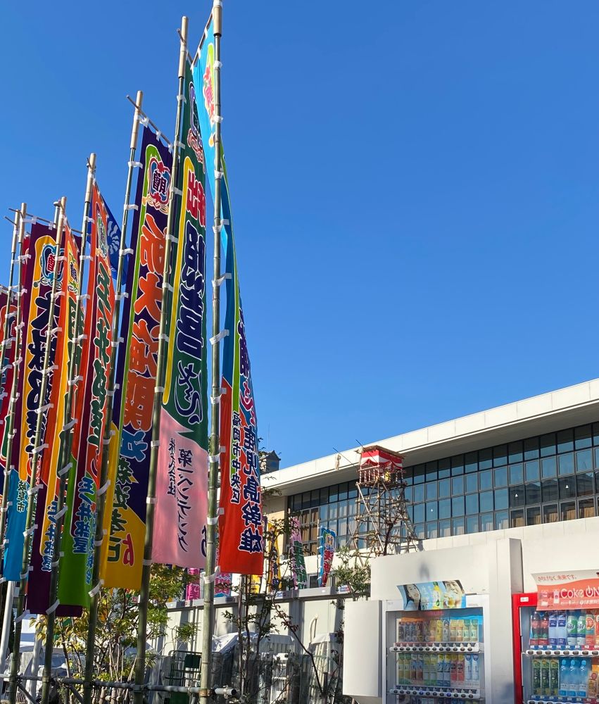 大相撲九州場所の会場福岡国際センターです。
快晴の下、建物前には太鼓櫓、会場入口前に色鮮やかな相撲幟が立てられています。