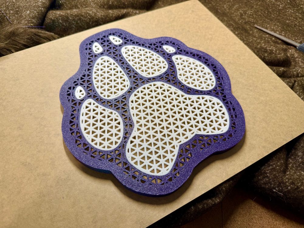 Paw print design 3d printed pin board in a purple sparkle filament outline and white paw pads and claws. 