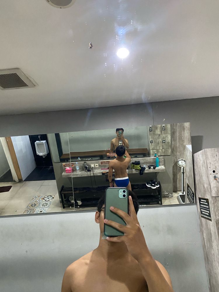 A man take a mirror selfie in a gym