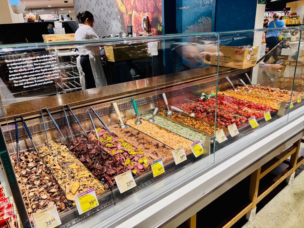 A row of poke choices sold by the pound at Foodland Farms grocery store. 