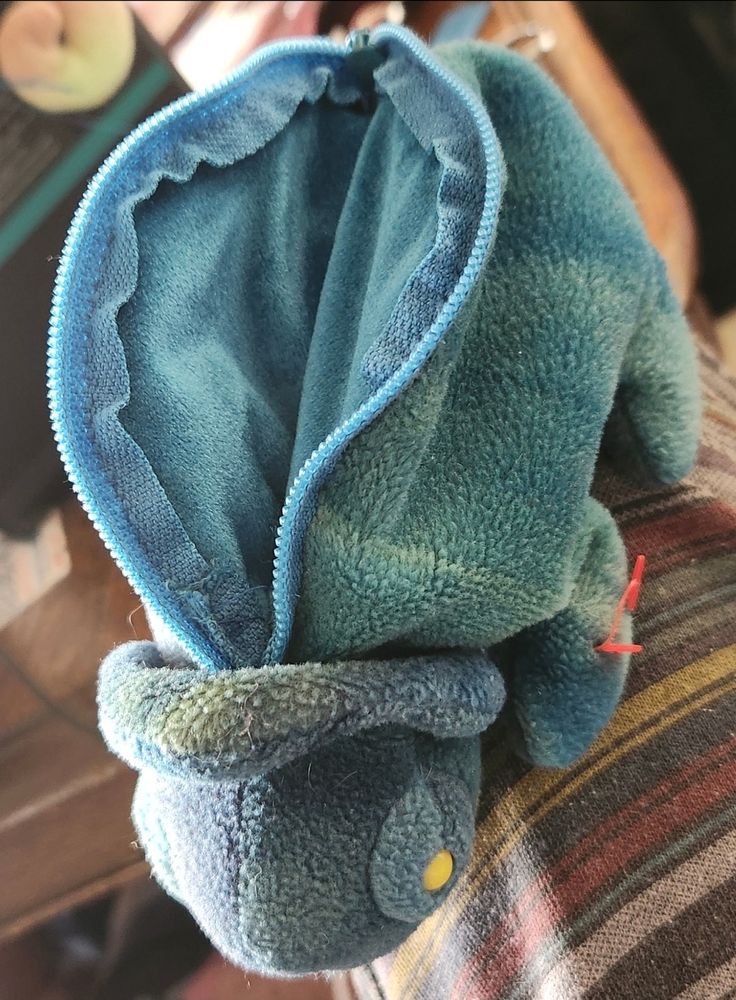 The beanie baby chamelion with the zipper open to show the velvet liner pouch inside