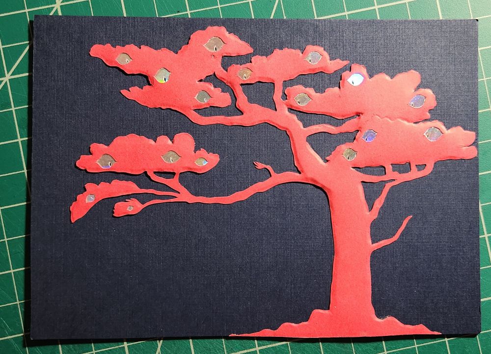 The red tree with many holographic eyes, glued and textured on a dark blue background.