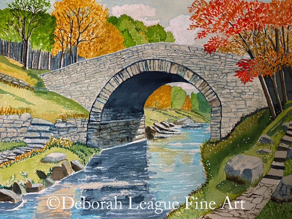 This watercolor painting captures a peaceful autumn landscape featuring a charming stone bridge arching over a gently flowing stream. The scene is framed by vibrant fall foliage in hues of red, orange, and green, creating a harmonious contrast. Soft reflections in the water and carefully detailed stonework enhance the tranquil, picturesque setting, inviting viewers to experience a moment of serenity in nature.