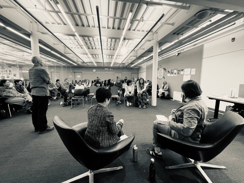 Group gathering with two seated speakers at front 