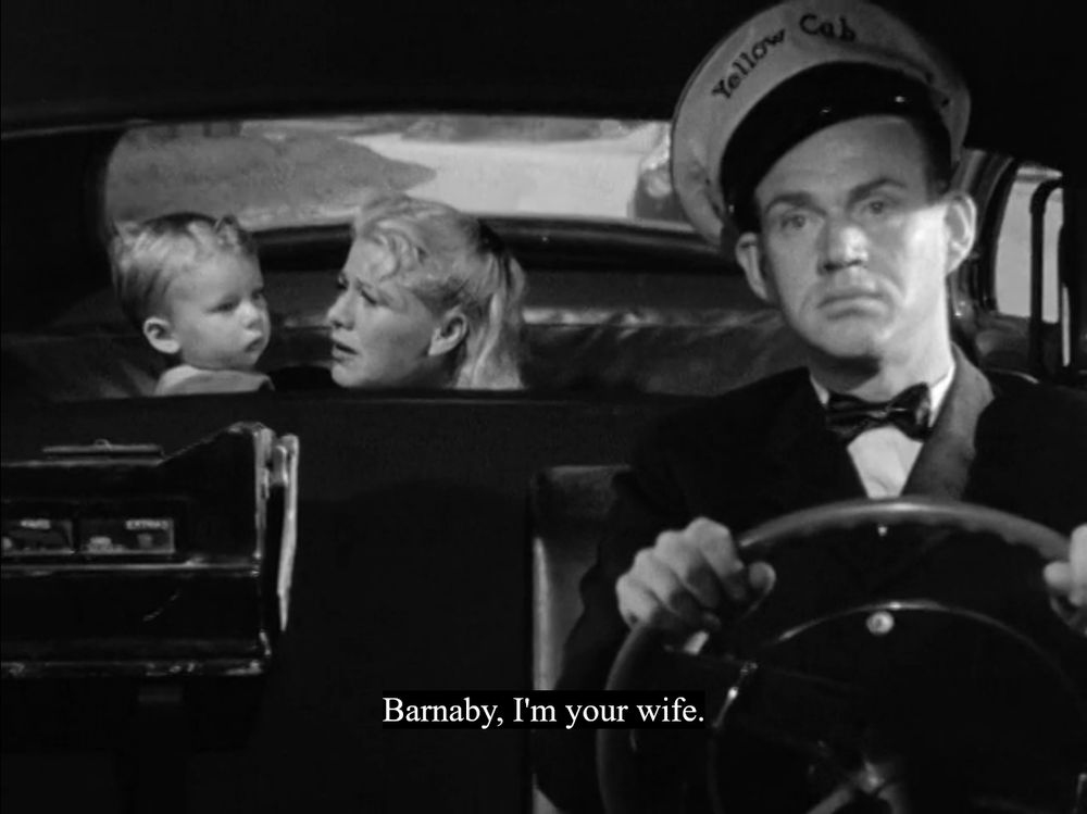 Black and white film still of Ginger Rogers in the backseat of a taxi speaking to a toddler; a caption reads: "Barnaby, I'm your wife."