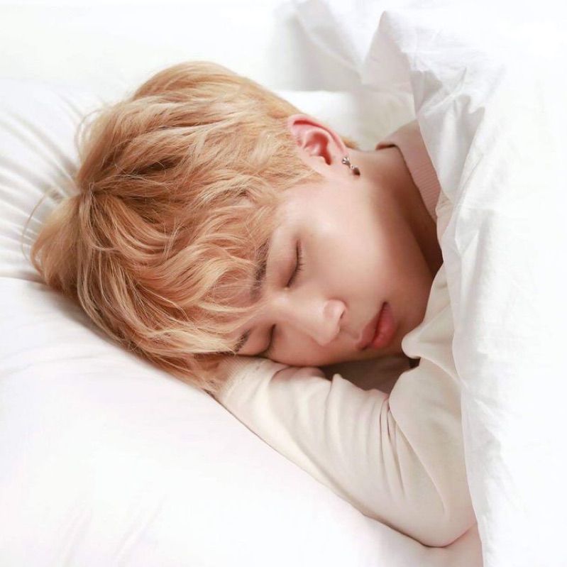Blonde Serendipity Jimin sleeping on a white bed 