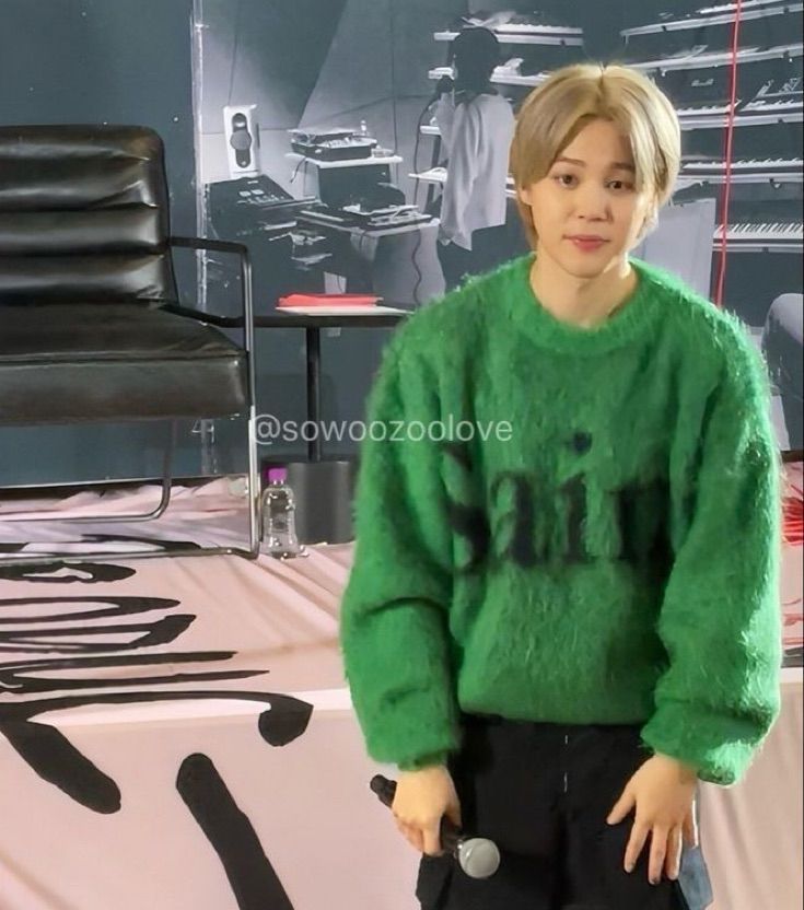 Jimin at his fanmeet in 2023. He has blonde hair, a fluffy green sweater, and cargo pants. 