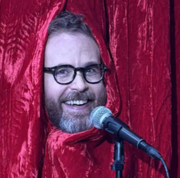 Sam Riech sticking his head through red curtains in an, um, evocative way