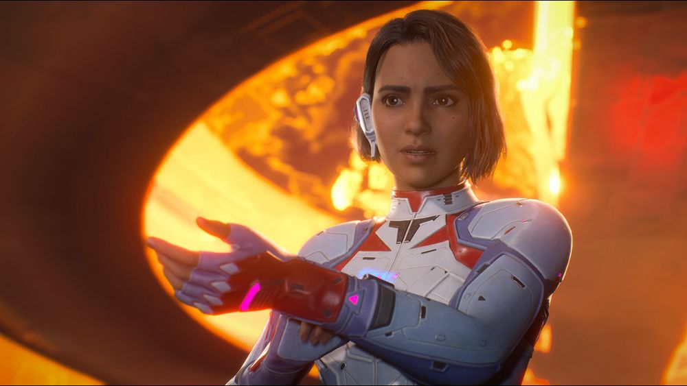 Split Fiction hero Mio - a feminine character with dark bobbed hair and lighter brown skin - reaches a hand out towards the camera. She's wearing slimline grey and white sci-fi space suit and an ear piece of some kind. Behind her, a fiery explosion rages.
