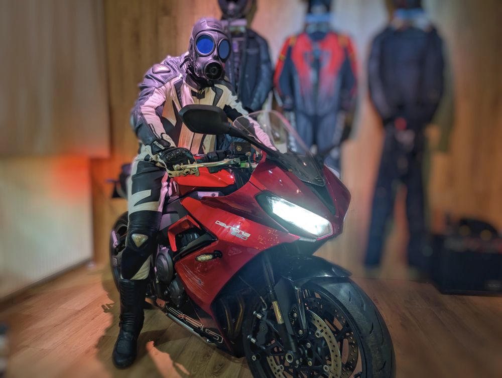 guy with gas mask sitting on a red motorcycle