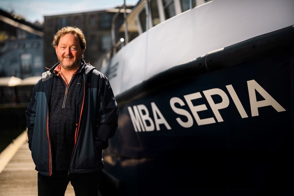 Dr Bryce Stewart next to research vessel, MBA Sepia. Photo by © The Marine Biological Association.