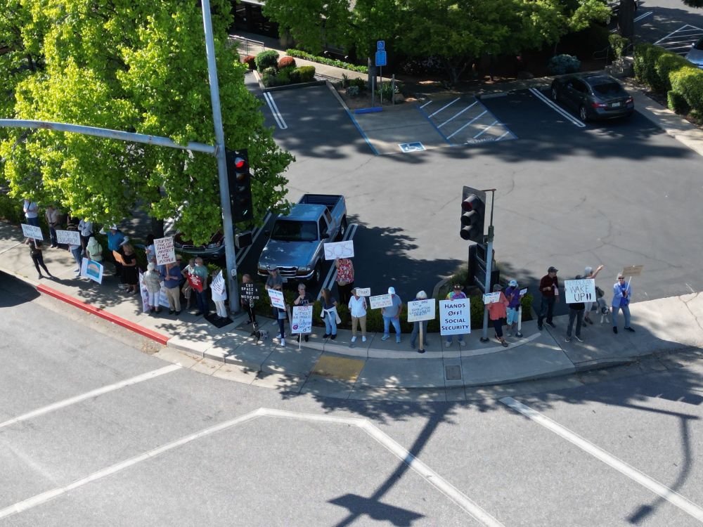 Drone photo of about 35 protesters on a street corner in Auburn CA