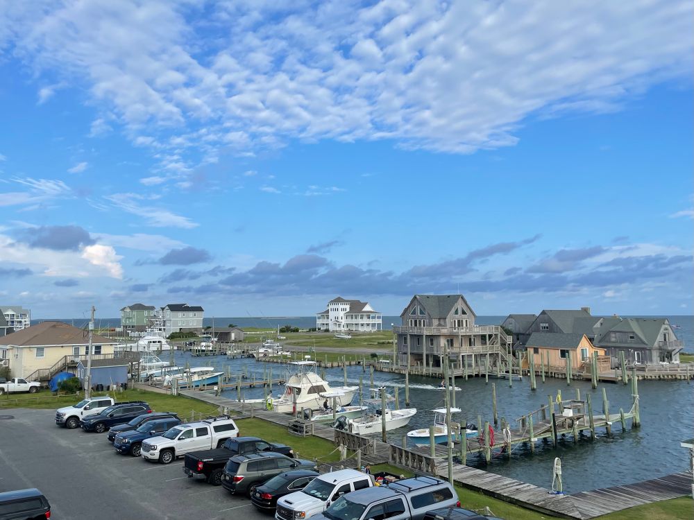 Blue sky morning with gray and white clouds overlooking dock area in Hatteras, NC