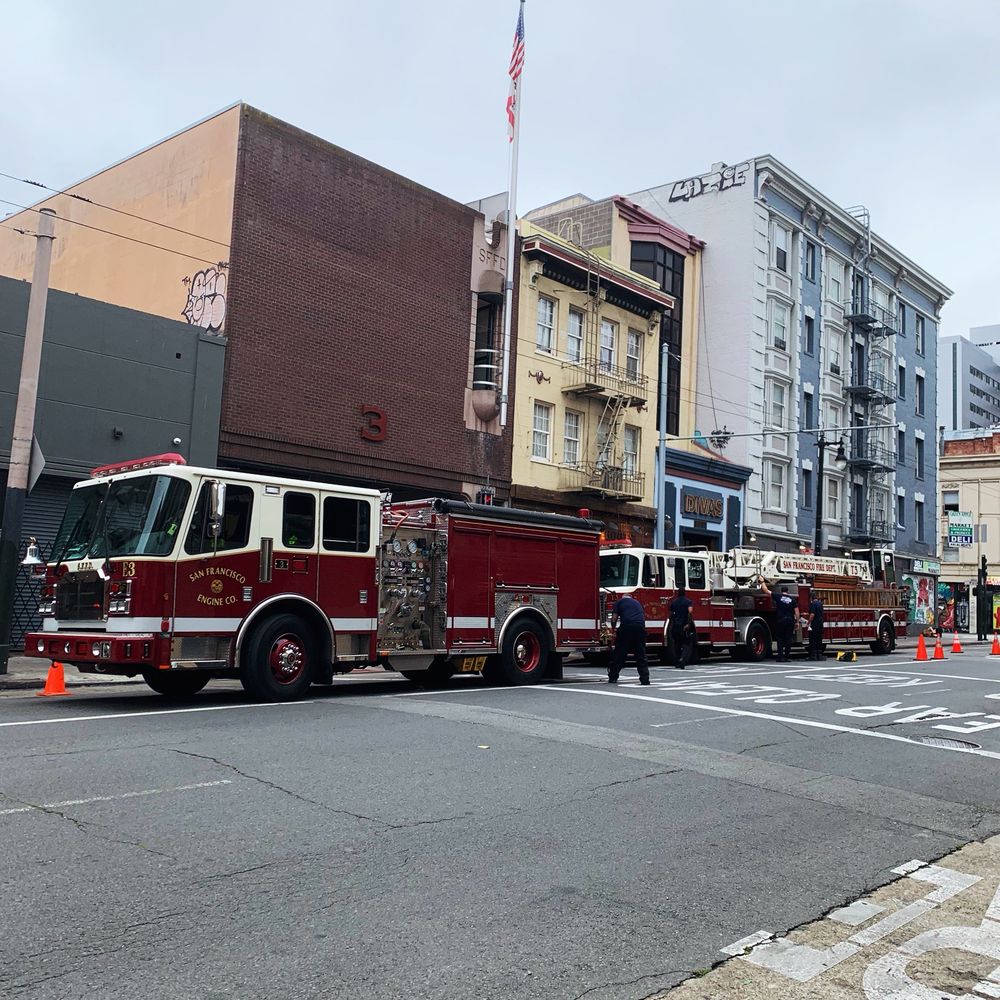 Deep burgundy fire trucks getting cleaned on the street