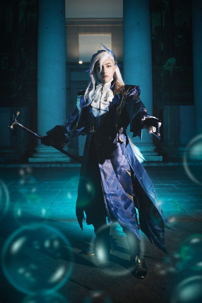 Fotografía de cosplay con un traje de Neuvillette del Genshin Impact, realizada con flashes en un entorno oscuro para darle más dramatismo.