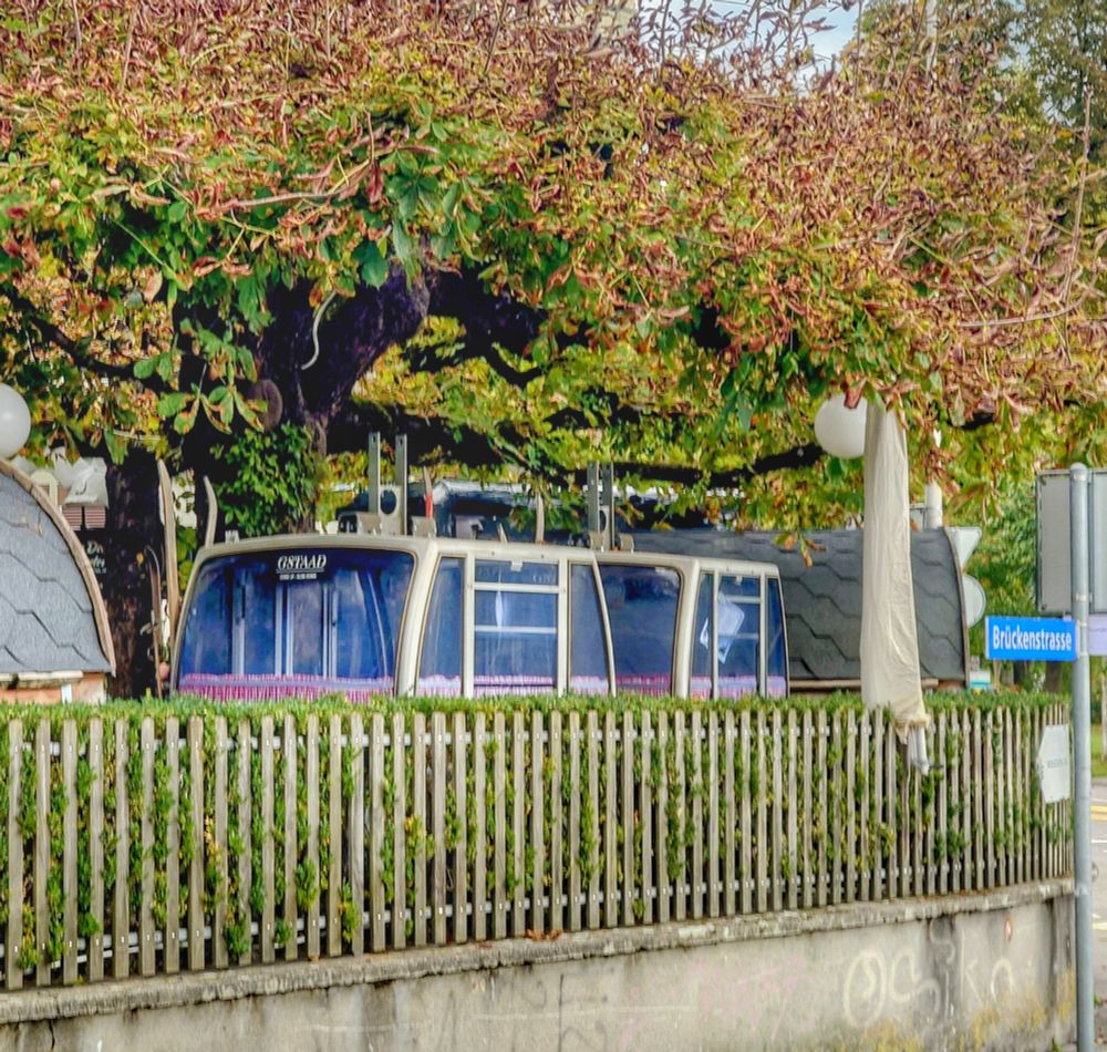 Seilbahnkabinen mit angeschnallten Uralten Skis, unter Bäumen,wartend auf Gäste die darin ein Fondue 🫕 geniessen wollen 