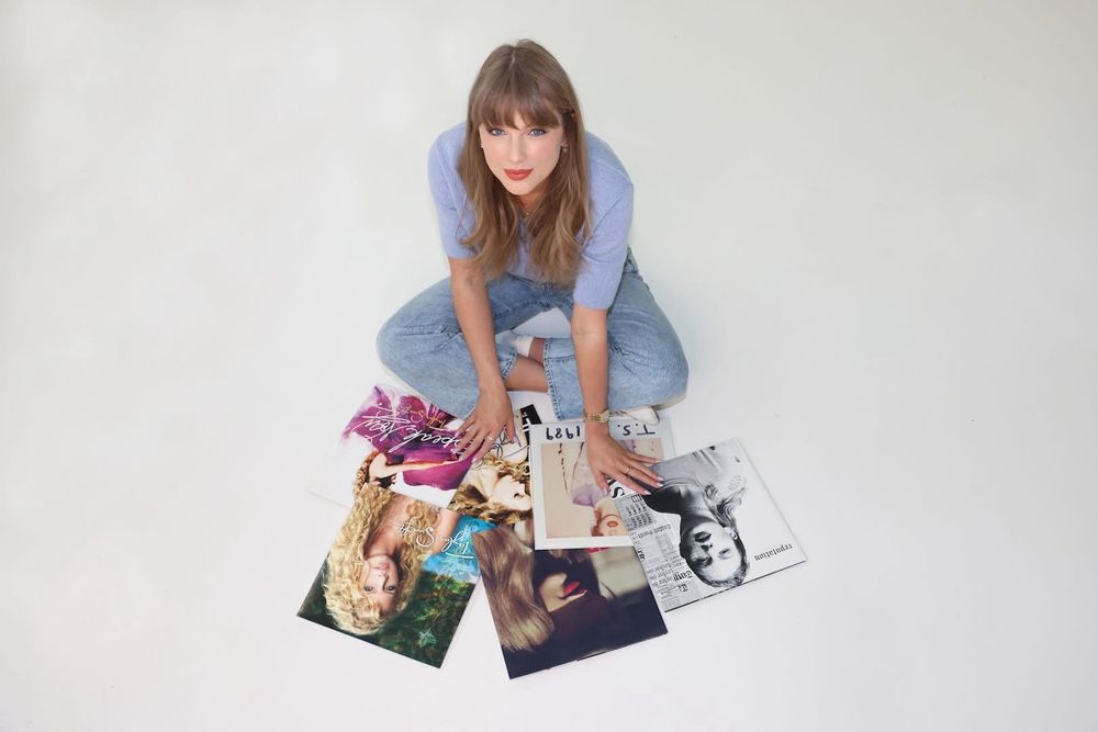 Taylor Swift poses with her first six albums
