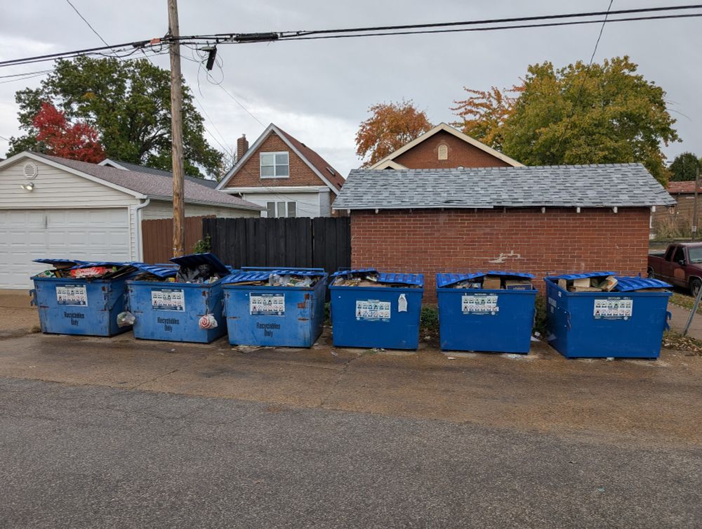6 overflowing recycling dumpsters