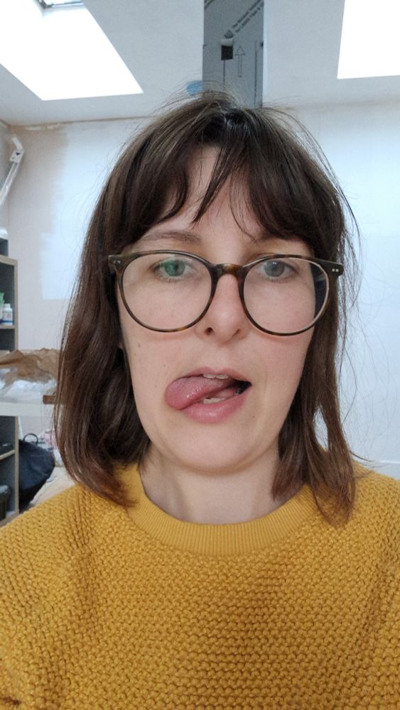woman with glasses sticks tongue out to the side