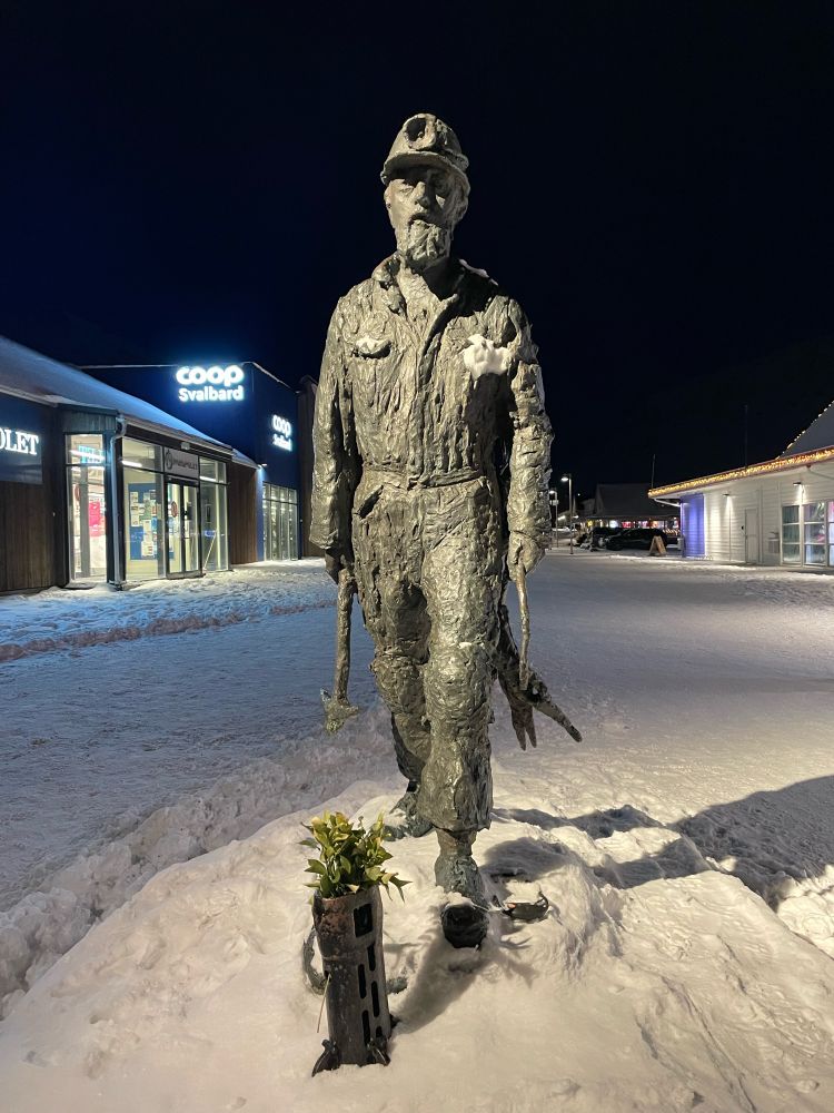 A statue of a miner in Longyearbyen take at 3pm when it’s all dark.