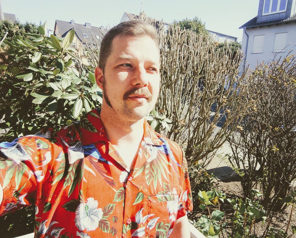 Selfie des Accountinhabers, vor einigen Jahren, mit Schnurrbart, Monsterkoteletten und rotem Hawaiihemd a la Magnum 