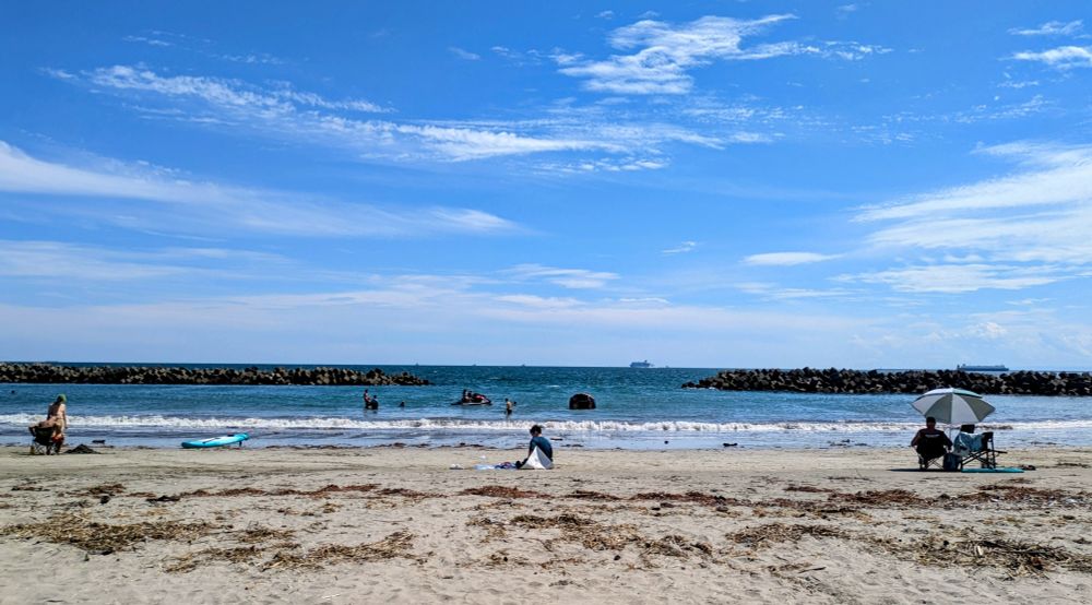 真っ青な空、筋状の白い雲、空よりはすこし緑色の海、砂浜