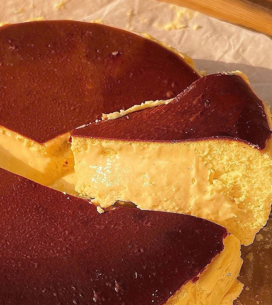 Foto de um cheesecake clássico, com uma fatia sendo cortada