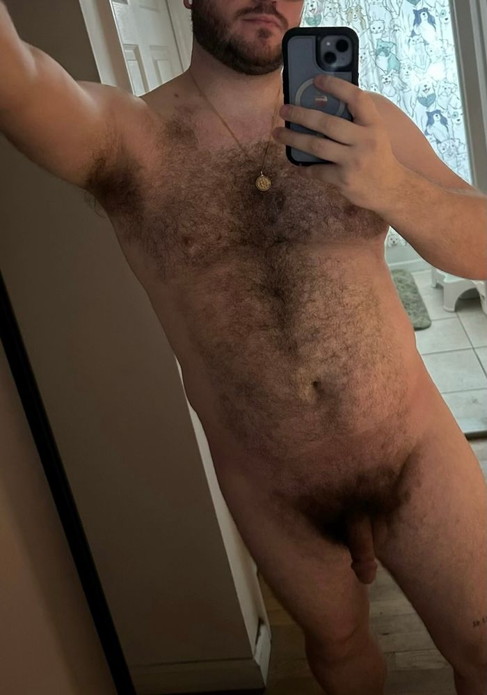 A naked mirror selfie with a soft penis