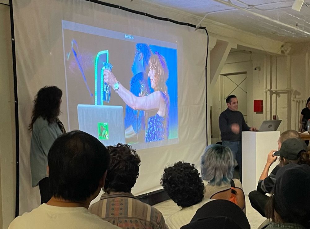 Picture of a slide being presented with a woman (me) spraying a spray bottle 