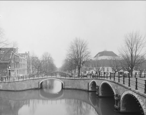 Links Reguliersgracht 80-92 (v.r.n.l.) en de bruggen 73 en 74 (Kerksluis) over de Reguliersgracht. Rechts de Duyfjesbrug (brug 71) over de Prinsengracht naar het Amstelveld met de Amstelkerk op de nummers 2-12.
Vervaardiger
Oord-de Pee, Annemieke van
Collectie
Collectie Het Grachtenboek
Datering
1990 ca.
Inventarissen
http://archief.amsterdam/archief/30803/405