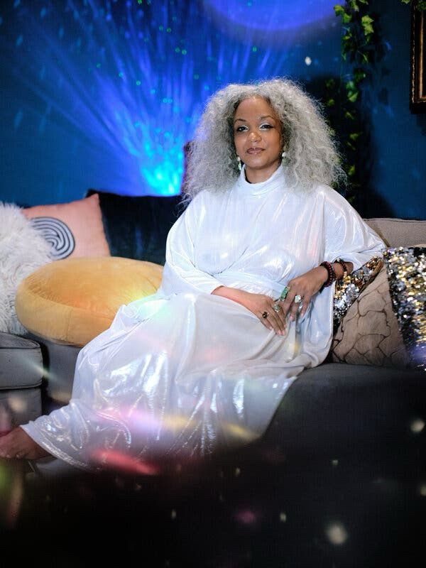 Picture of Sinnamon in an iridescent white gown on a couch. Taken for the New York Times 