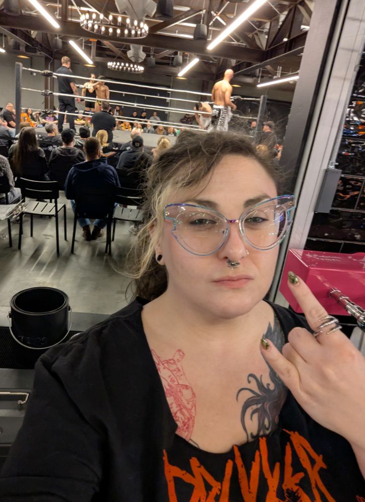 myself mean mugging throwing horns with the ring behind me