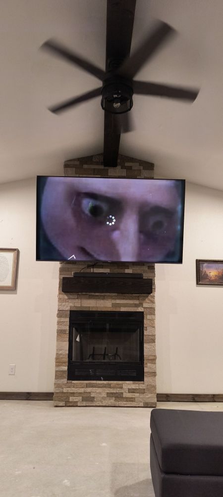A large TV featuring a buffering YouTube video stuck in a frame of Gru from Dispicable Me blank staring into the distance
