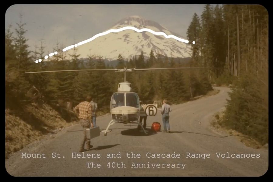 Scientists loading helicopter with scientific equipment on forested road with Mt St Helens in background.  White line drawn on volcano showing the modern profile of mountain after eruption.