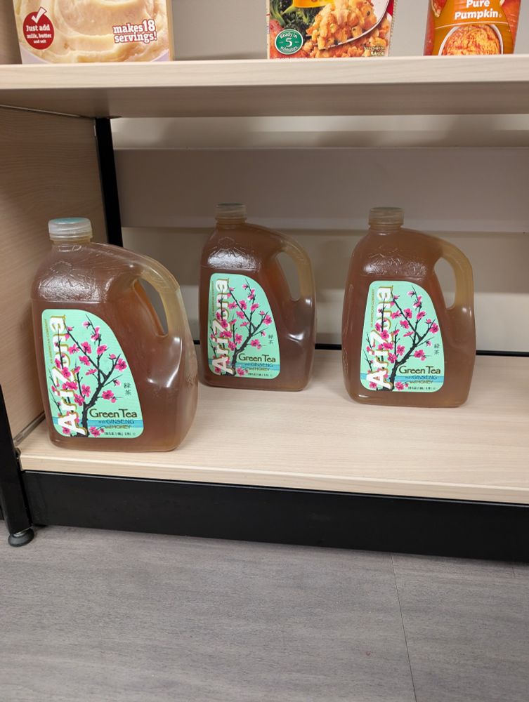 Three plastic cans of Arizona Green Tea