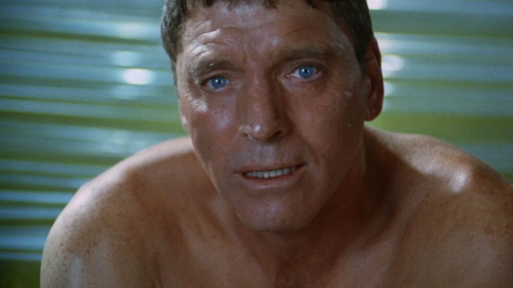 Burt Lancaster in THE SWIMMER, looming out of the water that shimmers behind him. 