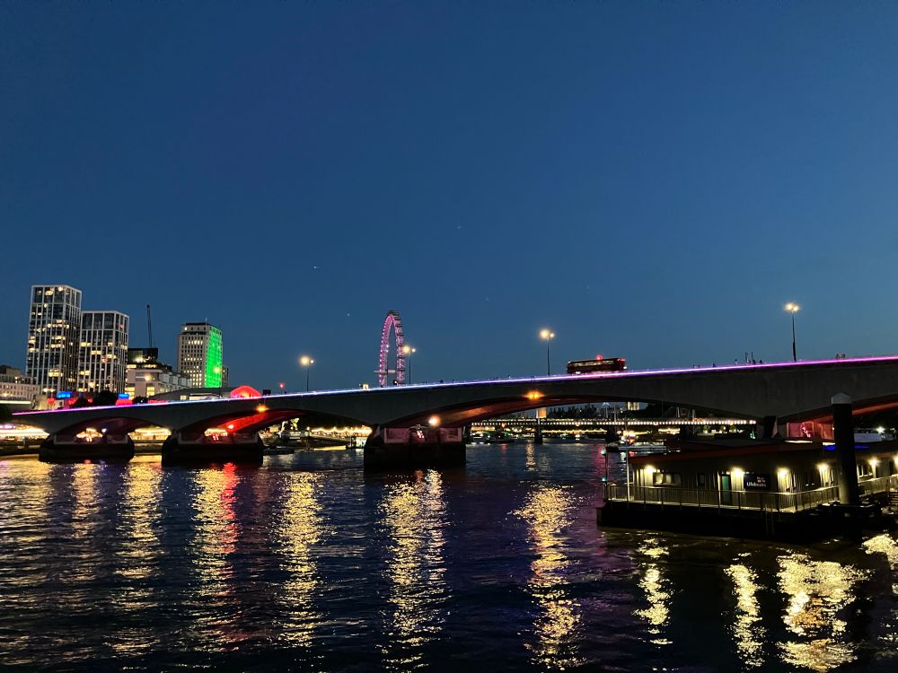 The Southbank from the north side of the Thames, lights reflected in the river at twilight on a summer night. 
