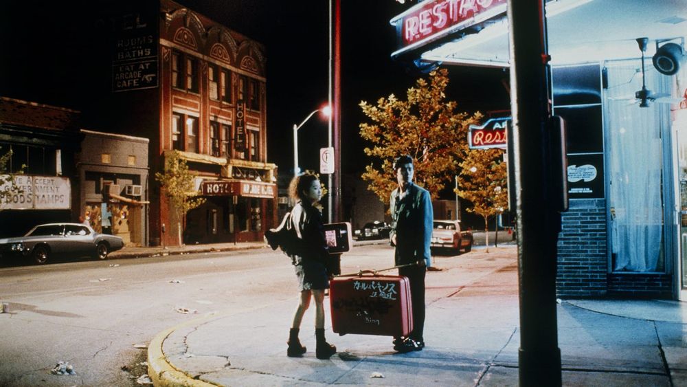 A young Japanese couple Jun (Masatoshi Nagase) and Mitsuko (Youki Kudoh) carry their huge pink suitcase through downtown Memphis at night in MYSTERY TRAIN (1989)