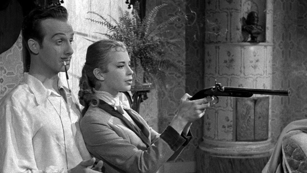 Margit Carlqvist and Jarl Kulle in Smiles of a Summer Night. They are standing in a bedroom. He is smoking a cigarette in a holder, she is brandishing a flintlock pistol. 