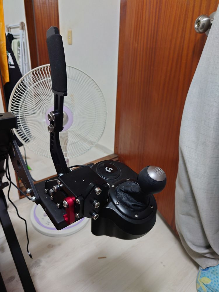 레이싱 휠 거치대에 로지텍 H 시프터와 핸드브레이크가 같이 달려있는 사진