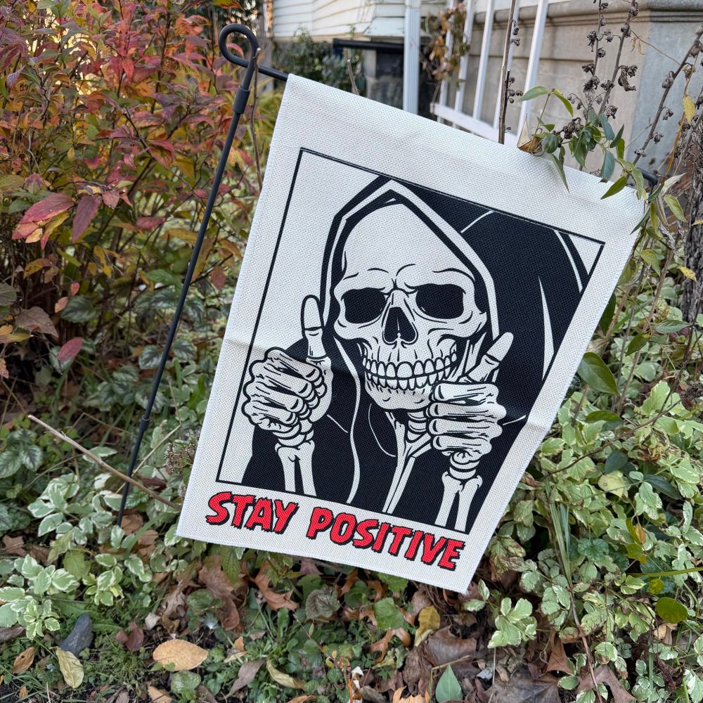 Yard sign of a skeleton saying stay positive 