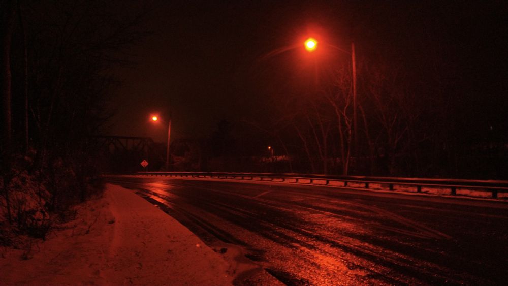 a late night winter road, with deep red street lamps lighting everything