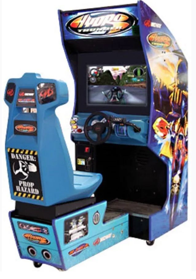 The arcade game hydro thunder with chair and arcade cabinet.