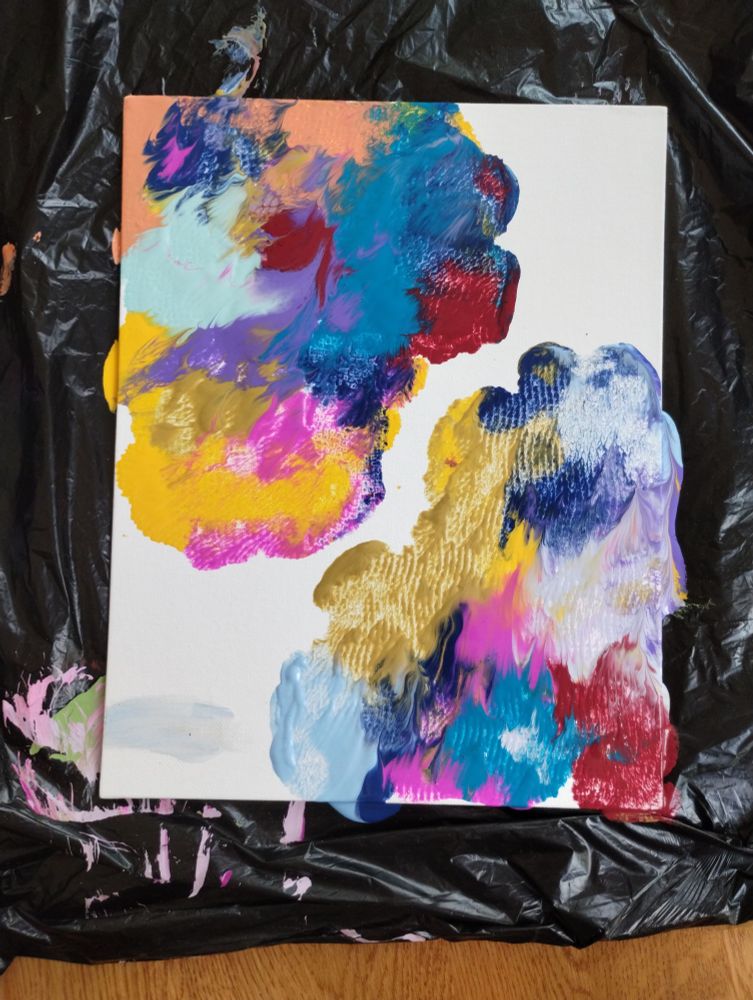 A photo of an abstract painting, using red, blue, gold, pink, purple, orange, yellow, turquoise, and sky blue paint.