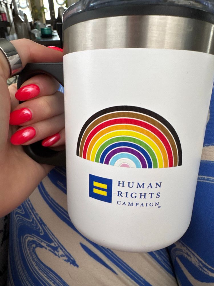Human rights campaign logo and rainbow on a coffee mug