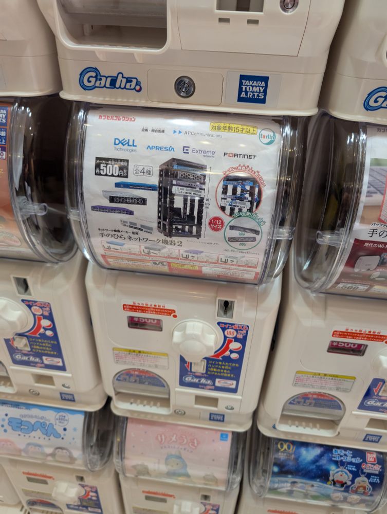 A gatchapon machine serving mini models of server equipment and server racks, complete with network cables.